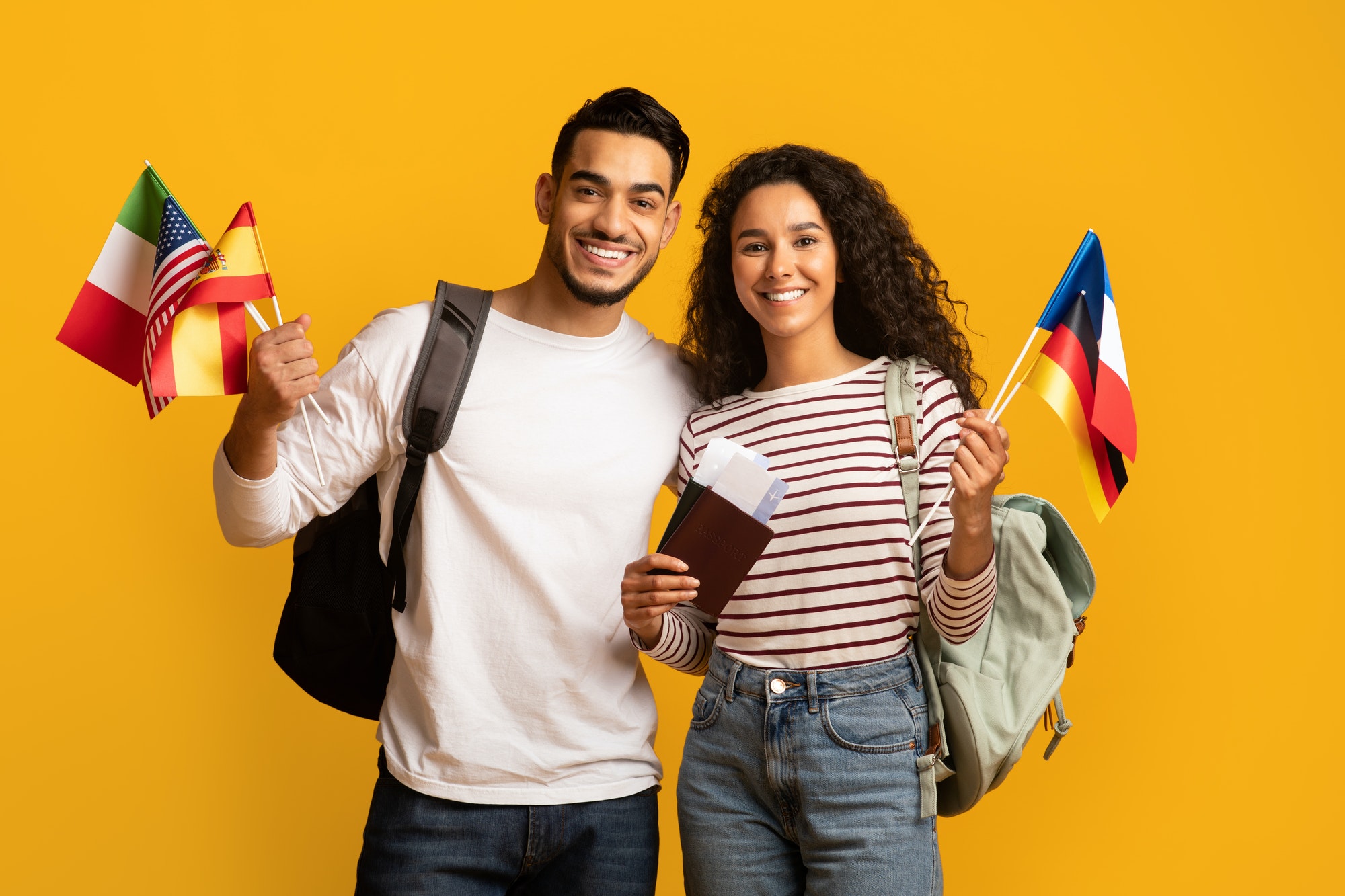 Travelling Abroad. Arab Tourists Couple Holding Passports With Tickets And International Flags